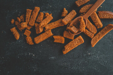 Wooden bowl filled with crispy rye croutons placed on a burlap cloth, creating a rustic snack...
