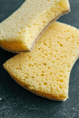 Close-up of two sponges on a black background, showcasing different textures. Ideal for illustrating household cleaning, sanitation, and eco-friendly cleaning supplies