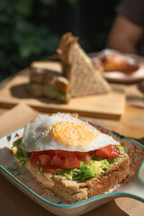 Toasted bread with tomato, avocado and egg. Photo of breakfast for an institution, Delicious food. Culinary concept.