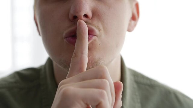 A man closes his mouth so as not to make sounds.
The man is trying not to talk.
Closed mouth.
Gesture of silence.
Complete silence.
Shut your mouth.
Don't say anything