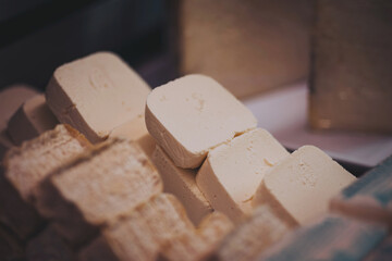 local cheeses displayed at the market stall. Organic food. aged cheeses for sale in the dairy. Gastronomy in Italy.