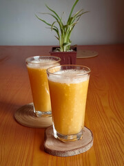 wood apple juice in glass is placed in dining table