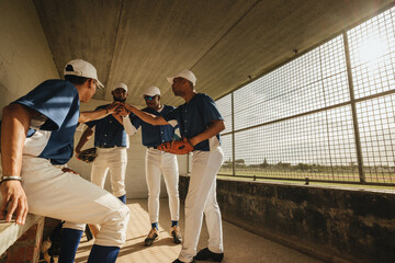 Amateur baseball league players in team huddle in the dugout