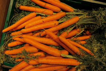Carrots laying on top of each other in a supermarket or farmers market for sale, orange carrot texture.