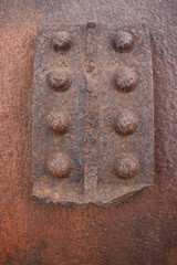 rough iron plating on an old iron compressor. Old rusty compressor. Corrosion texture and color. Rivets, plating, iron. Industrial, industrial boiler.