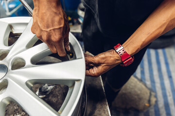 Mechanic removing a tire from the rim after using a tire bead breaker at  shop. workers remove the...