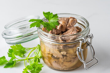 Cod liver in a jar with parsley on white background. Natural source of omega 3 and vitamin D. Keto...