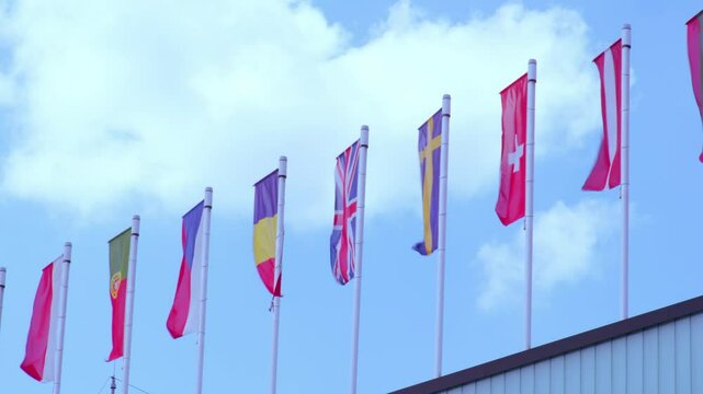 national flags Europe and other countries on satin flutter in wind in blue sky, European Space Agency, state symbols, concept international cooperation, global business