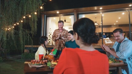 Family together celebrate anniversary in garden. Senior give gift to granddaughter. Outdoor camping activity to relax with relatives, spend time with multigeneration cross generation gap. Divergence.