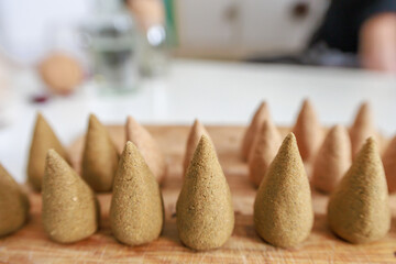 Close view of incense cones on a wooden board.