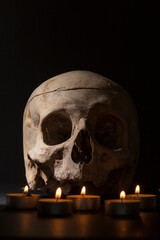 skull with candles on a dark background, allusion to Halloween