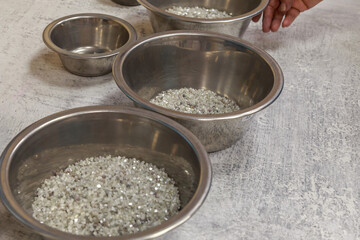Assortment of beautiful rough diamonds in bowls.