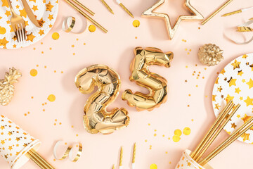Number 25 balloon celebration. Glamorous 25th birthday party setting with gold balloons, confetti and cutlery on pink background creating a festive and elegant atmospher