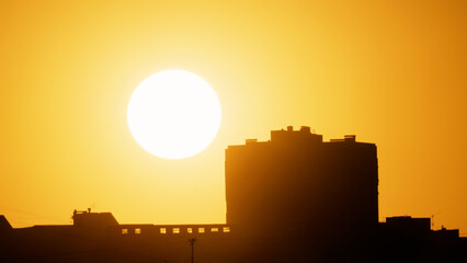 Big sun and a view of the rooftops of the city