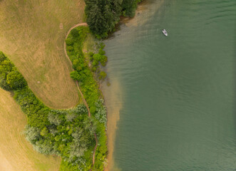 A boat is floating on a lake near a forest