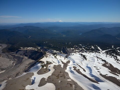 A mountain range with a snow covered peak in the distance