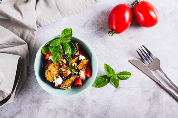 Appetizing salad of fried eggplant, tomatoes and ricotta in a bowl on the table top view