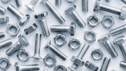 Many metal nuts and bolts on white background
