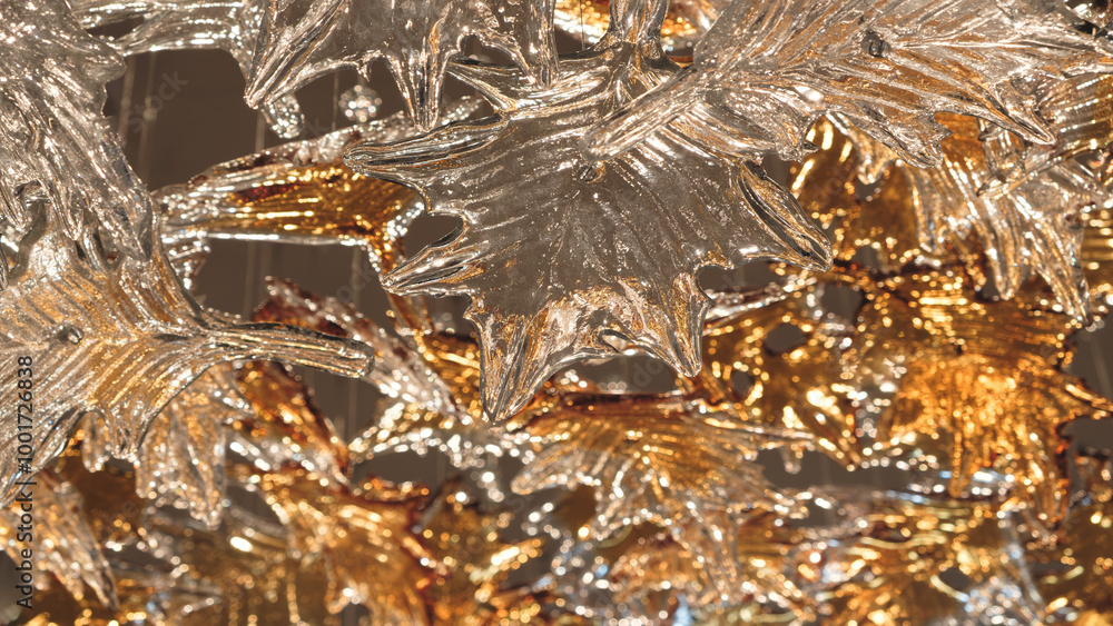 Poster a close up of a leafy tree with gold and silver leaves as background. the leaves are shiny and refle