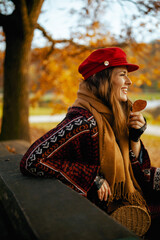 happy trendy woman in red hat with autumn leaf