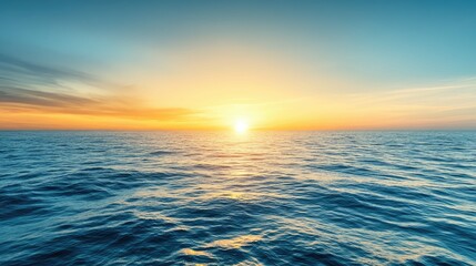 Obraz premium A stunning sunset over the vast ocean with a golden horizon and blue sky.