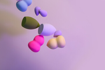 Flying different makeup sponges on purple background