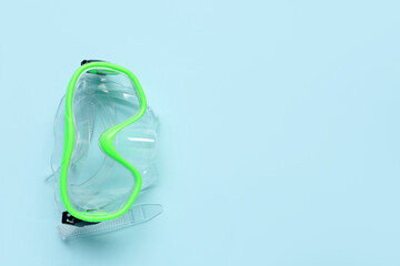 Green swimming mask on blue background