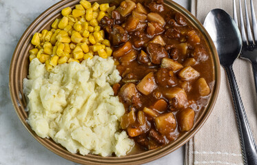 beef stew with  buttered mashed potatoes and corn,