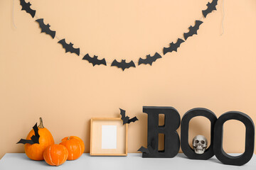 Halloween pumpkins with frame and word BOO on commode in room