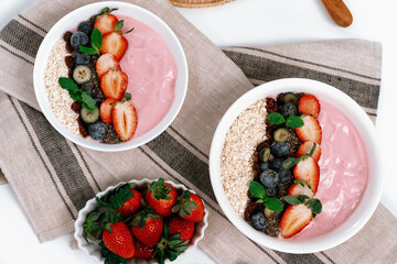 Presented by fruits putting yogurt toppings with strawberry, berry, oats, raisins and chia seed...
