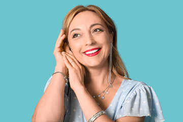 Fototapeta premium Beautiful mature woman with stylish accessories on blue background