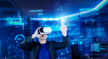 Project manager with VR goggles pointing financial chart and glowing blue light at office. Skilled businessman checking and planning marketing strategy by using data from augmented reality. Ingenuity.