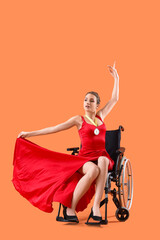 Young dancer in wheelchair with first place medal on orange background