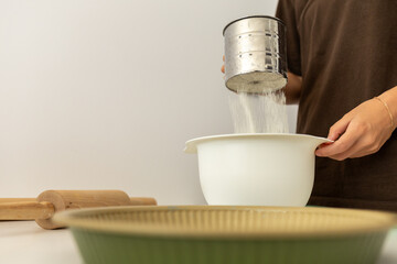 girl sifting flour for baking, cooking at home