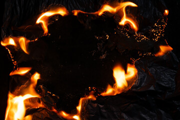 burning paper, glowing edge of paper on a black background