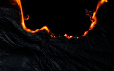 burning paper, glowing edge of paper on a black background