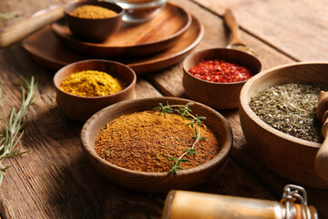 Bowls with fresh aromatic spices on wooden table