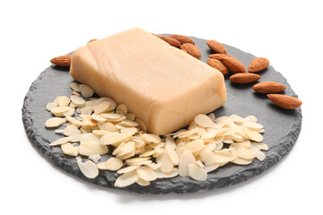 Slate board with tasty marzipan bar, almond nuts and flakes on white background