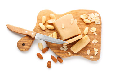 Wooden board with marzipan bar, almond nuts and knife on white background