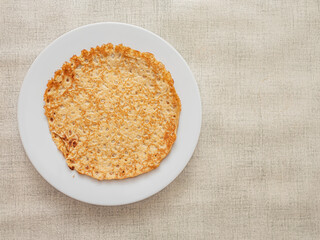 Round pancake or crepes on big plate and simple table cloth. Popular multi national dish.