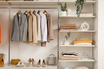 Wardrobe with shelves, female clothes and shoes in walk-in closet