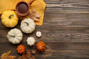 Composition with candles, cup of tea and ripe pumpkins on wooden background