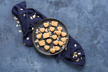 Plate with tasty marzipan candies, almond flakes and napkin on color background