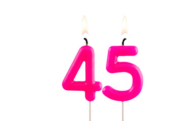 Pink number 45 birthday candle lit on white background