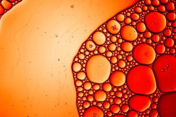 Textured river of vegetable oil in a close up with bubbles in an abstract of red