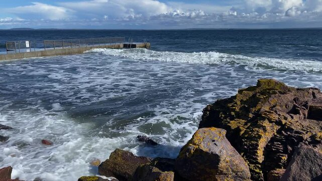 Stormy sea with rocks in the foreground, pier and waves under a cloudy sky, beach, Oslofjord, T&ouml;nsberg, Norway, Europe