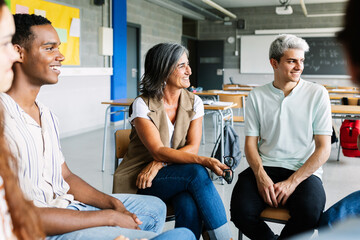 Young high school students talking with teacher in focus group therapy session. Education concept