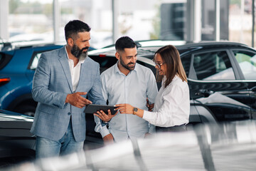 Showroom interaction showcasing car details on digital device.