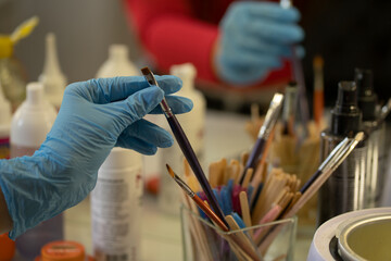 hand of a make up and brow artist taking a brush for work