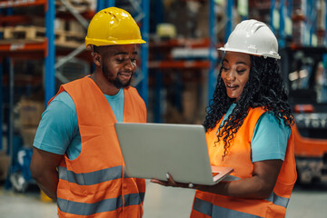 Warehouse teamwork: african american colleagues checking laptop together